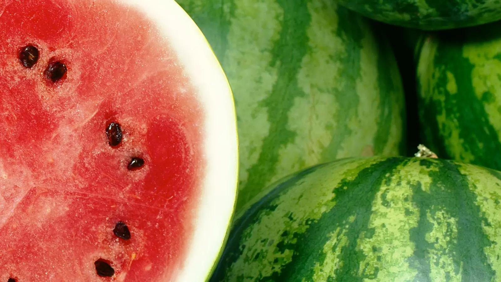 Melancia cortada com fundo de melancias verdes